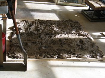 9. Spreading out a tubful of daub to evaporate some of the water.