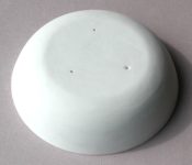 A ceramic form coated with battwash. There are three air holes to prevent the vessel sticking to the form due to suction.