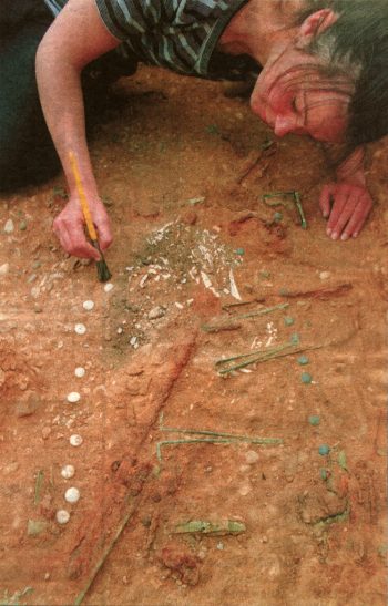 The beads are laid out ready to play. Most of the wooden box that contained the game has rotted away, but the hinges and metal edges can still be seen