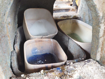 A pot containing white glass piled on top of a pot containing cobalt blue glass