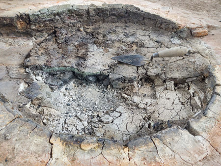 Section through the glass/ash layer and the tiles, and showing some of the baked daub in front of the section