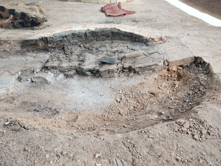 The thin layer of soil under the fired daub. The central grey area is the result of organic matter in the hardcore below which has burnt in anaerobic conditions.