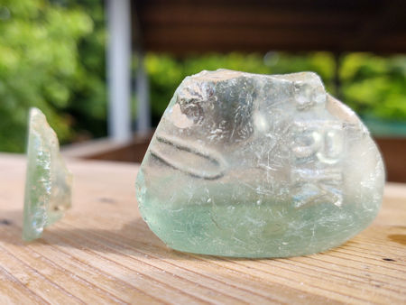 Two late 19th century glass bottle fragments. These were found in the hardcore immediately below the centre of the firepit. The lack of heat damage shows that the temperature in the hardcore was probably less than the softening point of the glass (about 560°C