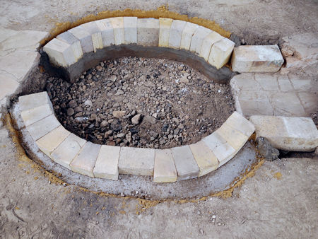 A layer of hardcore as a foundation for the floor of the firepit