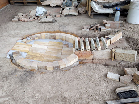 The firepit finished with castable refractory concrete. The lower stokehole bricks and the grate temporarily in position.