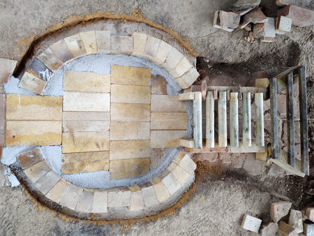 The firepit finished with castable refractory concrete. The lower stokehole bricks and the grate temporarily in position.