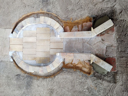 Showing the sand, tiles and mortar behind the lower stokehole walls