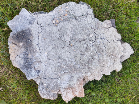 The underside of the glass/ash spread, showing the fired daub and the tiles