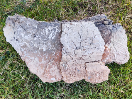 The underside of part of the firepit wall, showing tiles and fired daub