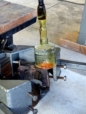 Removing the blown bottle from the mould